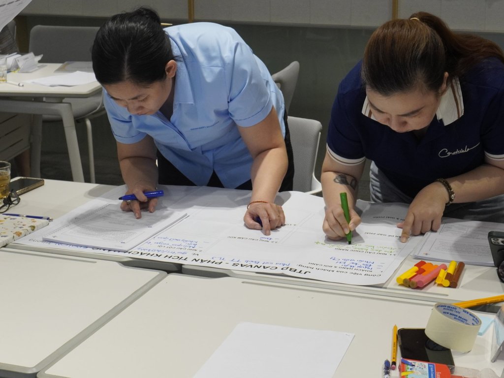 Cận cảnh hai thành viên ghi số liệu lên bàn cờ tài chính